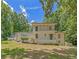 Charming two-story house with white exterior, upper balcony, surrounded by lush green trees, and blue skies at 315 Renae, Marietta, GA 30060