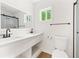 Modern bathroom featuring double sinks, white cabinets, and a shower with black hardware accents at 4103 Brenda Dr, Decatur, GA 30035