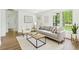 Sunlit living room with stylish decor, featuring a comfortable sofa, modern artwork, and large windows at 4103 Brenda Dr, Decatur, GA 30035