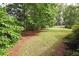 Expansive backyard with lush greenery, mature trees, and manicured lawn at 4314 Woodhaven Se Way, Smyrna, GA 30082