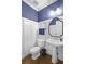 Charming half bathroom featuring blue accent wall, white paneling, and modern fixtures at 4314 Woodhaven Se Way, Smyrna, GA 30082