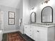 Bathroom featuring double vanities, white cabinets, black hardware, and elegant mirrors at 4314 Woodhaven Se Way, Smyrna, GA 30082