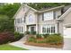 Charming two-story home featuring a landscaped front yard, stone walkway, and elegant architectural details at 4314 Woodhaven Se Way, Smyrna, GA 30082