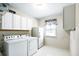 Functional laundry room with white washer, dryer, refrigerator, and ample cabinet storage at 4314 Woodhaven Se Way, Smyrna, GA 30082