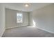 An empty bedroom with neutral walls, plush carpet, recessed lights, and a large window at 4511 Twinberry Dr, Powder Springs, GA 30127