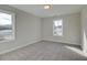 A cozy bedroom featuring neutral walls, carpet, and two windows bringing in lots of natural light at 4511 Twinberry Dr, Powder Springs, GA 30127
