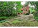 Backyard with stone patio, brickwork and lush greenery surrounding the property at 50 Rumson Ne Way, Atlanta, GA 30305