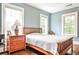 Bright bedroom featuring hardwood floors, three windows with natural light, and a wooden bed frame at 50 Rumson Ne Way, Atlanta, GA 30305