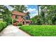 Beautiful brick home showcasing a manicured front lawn, mature trees, and charming architectural details at 50 Rumson Ne Way, Atlanta, GA 30305