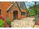 Inviting brick front porch with stone walkway features an arched entryway and lush landscaping at 50 Rumson Ne Way, Atlanta, GA 30305