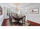 Formal dining room with elegant chandelier, detailed trim work, and gleaming hardwood floors at 2922 Heart Pine Way, Buford, GA 30519
