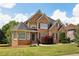 Beautiful brick home featuring a well-manicured lawn, dark shutters, and lovely landscaping at 2922 Heart Pine Way, Buford, GA 30519
