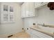 Well-lit laundry room includes a utility sink, and ample storage at 2922 Heart Pine Way, Buford, GA 30519