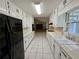 Galley style kitchen with all white cabinets, black appliances, and tile floors at 417 Ohern Ct, Stone Mountain, GA 30088
