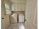 Bright laundry room features a washer and dryer, plus convenient overhead storage cabinets at 417 Ohern Ct, Stone Mountain, GA 30088