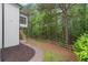 Exterior view showing a white home with a fenced yard surrounded by mature trees at 4294 Silver Peak Pkwy, Suwanee, GA 30024