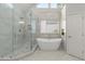 Luxurious bathroom featuring marble tiled shower, a soaking tub, and designer fixtures at 4294 Silver Peak Pkwy, Suwanee, GA 30024