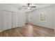 Bright bedroom showcasing hardwood floors, closet, and windows that let in natural light, creating a serene space at 4294 Silver Peak Pkwy, Suwanee, GA 30024