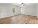 An empty room showcasing the hardwood flooring, neutral walls, a ceiling fan, and bright natural light at 4294 Silver Peak Pkwy, Suwanee, GA 30024