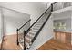 Elegant foyer features a staircase with black iron railings, hardwood floors, and a view to the living spaces at 4294 Silver Peak Pkwy, Suwanee, GA 30024