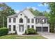 Beautiful two-story home featuring white brick, black window trim, attached two-car garage and landscaped front yard at 4294 Silver Peak Pkwy, Suwanee, GA 30024