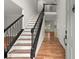 Elegant foyer with hardwood floors and a staircase featuring stylish black railing and white risers at 4294 Silver Peak Pkwy, Suwanee, GA 30024