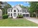 Beautifully landscaped front yard and well-maintained lawn with an inviting white brick home and gray garage doors at 4294 Silver Peak Pkwy, Suwanee, GA 30024