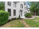Close up view of a landscaped yard with decorative trees and bushes in front of a white painted brick home at 4294 Silver Peak Pkwy, Suwanee, GA 30024