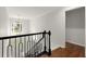 Bright hallway with hardwood floors, black railing, and natural light from front door at 4294 Silver Peak Pkwy, Suwanee, GA 30024