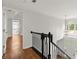 Elegant hallway with hardwood floors and rod iron banister leading to the home's entrance at 4294 Silver Peak Pkwy, Suwanee, GA 30024