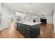 Open concept living room and kitchen with hardwood floors, fireplace, and staircase at 4294 Silver Peak Pkwy, Suwanee, GA 30024