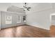 Bright main bedroom with tray ceilings, hardwood floors, and built-in shelving at 4294 Silver Peak Pkwy, Suwanee, GA 30024