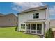 Backyard view of a two-story home with a screened porch and a lush, green lawn at 4514 Eastbrook Pl, Snellville, GA 30039