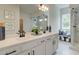 Well-lit bathroom with double vanity, elegant countertop, walk-in shower with seat, and marble-look tile flooring at 4514 Eastbrook Pl, Snellville, GA 30039
