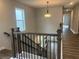 Hallway overlooking the staircase, features hardwood floors, natural lighting, and is well illuminated by decorative lighting at 4514 Eastbrook Pl, Snellville, GA 30039