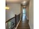 Bright hallway with wood floors and wood and metal banister railing, leading to bedrooms at 4514 Eastbrook Pl, Snellville, GA 30039