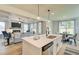Open-concept kitchen featuring a center island, pendant lighting, and views into the adjacent living and dining areas at 4514 Eastbrook Pl, Snellville, GA 30039