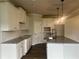 Modern kitchen featuring granite countertops, white cabinets, stainless steel appliances, and an island with pendant lighting at 4514 Eastbrook Pl, Snellville, GA 30039
