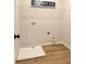 Functional laundry room with a washing machine tray, overhead shelving, and wood-look flooring at 4514 Eastbrook Pl, Snellville, GA 30039