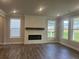 Bright and airy living room with hardwood floors, fireplace, and large windows that provide backyard views at 4514 Eastbrook Pl, Snellville, GA 30039