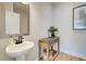 A quaint powder room with a pedestal sink, elegant fixtures, and a decorative accent plant at 4514 Eastbrook Pl, Snellville, GA 30039