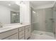 Modern bathroom features a double vanity, a large mirror, and a glass-enclosed shower with tiled walls at 4651 Larkfield Way, Powder Springs, GA 30127