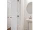 Stylish powder room with pedestal sink, round mirror, and white door with brushed nickel hardware at 4651 Larkfield Way, Powder Springs, GA 30127