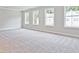 Spacious bedroom featuring plush carpeting and plenty of natural light from the three windows at 4651 Larkfield Way, Powder Springs, GA 30127