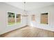 Sun-filled dining area with large windows, wood-look flooring, and modern chandelier at 4651 Larkfield Way, Powder Springs, GA 30127