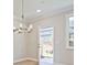 Bright dining room with modern chandelier and view to the backyard at 4651 Larkfield Way, Powder Springs, GA 30127