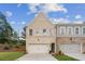 Charming townhome with a two-car garage, brick facade, and well-manicured lawn on a sunny day at 4651 Larkfield Way, Powder Springs, GA 30127