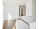 Bright hallway with hardwood floors, white walls, and a wooden banister leading to the upper level at 4651 Larkfield Way, Powder Springs, GA 30127