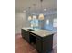A kitchen island with white countertops, a sink, and pendant lights above it is shown at 4651 Larkfield Way, Powder Springs, GA 30127