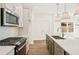 Bright open kitchen with stainless appliances, granite countertops, and pendant lighting at 4651 Larkfield Way, Powder Springs, GA 30127